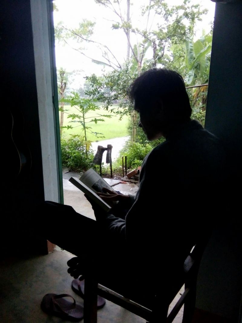 Nhat is at his reading corner, looking to the rice field 